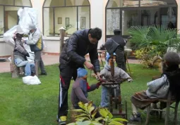 I volontari allestiscono il presepe nel giardino della casa di riposo